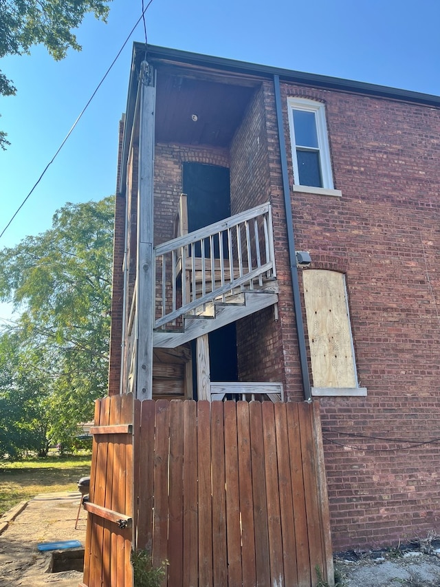 exterior space featuring brick siding and a balcony