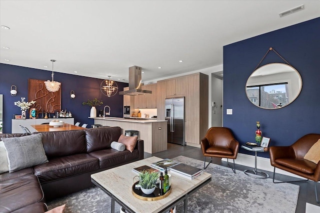 living area with recessed lighting, a notable chandelier, visible vents, and wood finished floors