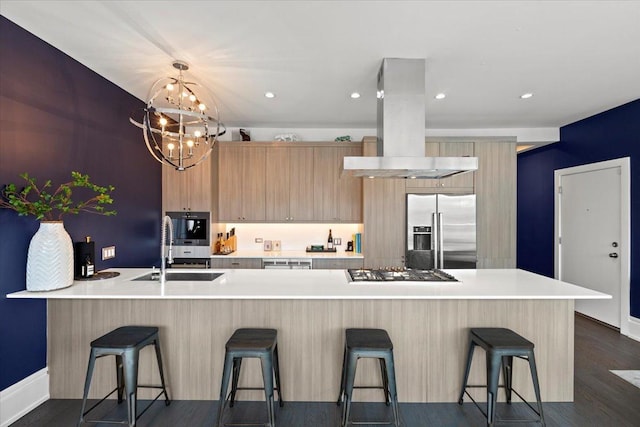 kitchen featuring a sink, light countertops, stainless steel appliances, island range hood, and modern cabinets