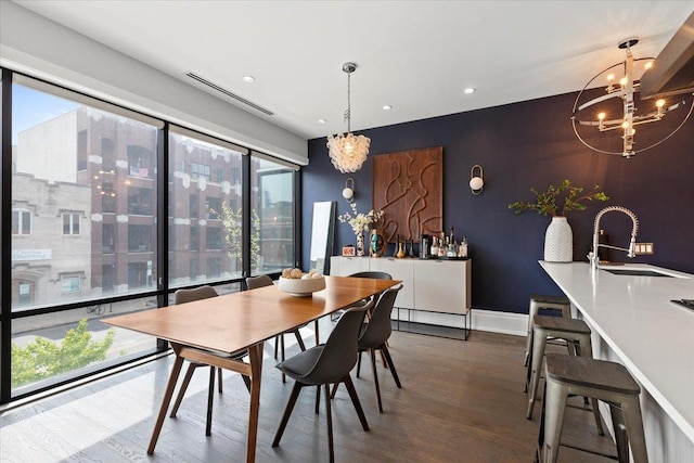 dining room with visible vents, wood finished floors, a notable chandelier, an accent wall, and recessed lighting