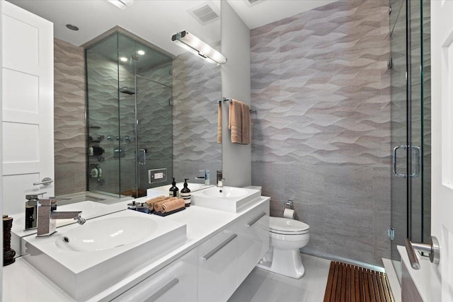 bathroom with a sink, tile walls, a shower stall, and toilet