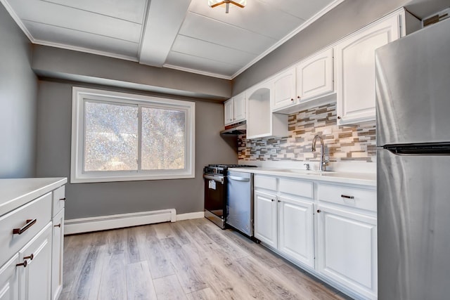 kitchen with a sink, appliances with stainless steel finishes, a baseboard radiator, ornamental molding, and backsplash