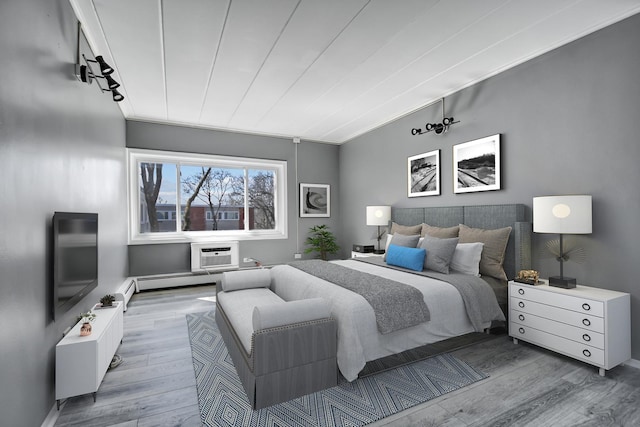 bedroom featuring a wall mounted AC and wood finished floors