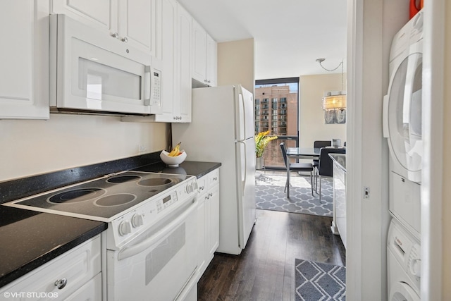 1122 N Clark St Unit 3501, Chicago, IL 60610 - kitchen with white appliances, stacked washer and dryer, white cabinets, and dark wood finished floors