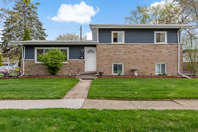 tri-level home with brick siding and a front yard