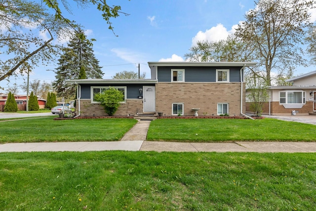 tri-level home with brick siding and a front yard