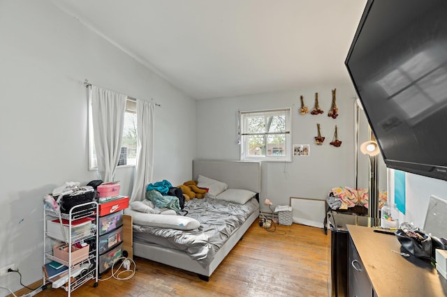 bedroom featuring wood finished floors and lofted ceiling