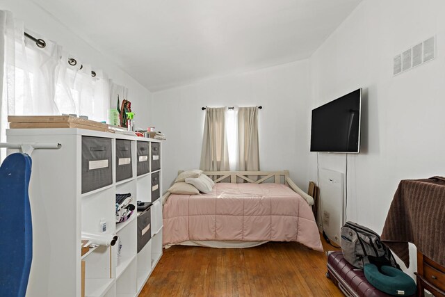 bedroom featuring visible vents, multiple windows, and dark wood-type flooring