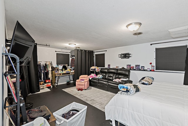 bedroom featuring a textured ceiling, concrete flooring, and visible vents
