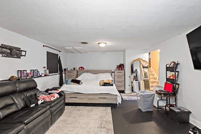 bedroom featuring a textured ceiling and finished concrete floors