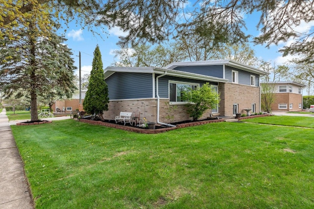 view of home's exterior featuring a yard and brick siding