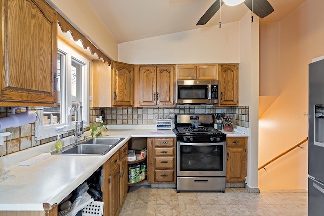 kitchen featuring a sink, brown cabinets, stainless steel appliances, light countertops, and lofted ceiling