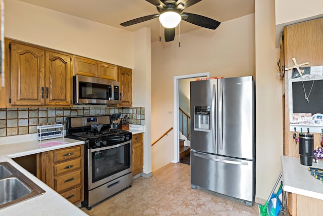 kitchen with brown cabinets, stainless steel appliances, ceiling fan, tasteful backsplash, and light countertops