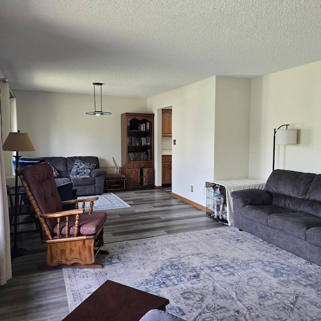 living room featuring baseboards, a textured ceiling, and dark wood-type flooring