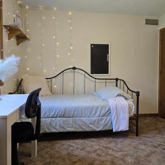bedroom featuring visible vents, a textured ceiling, and carpet