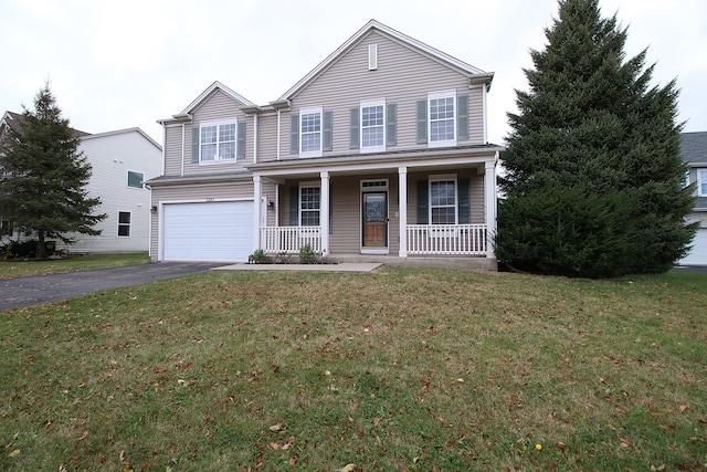 traditional-style home featuring a porch, a front lawn, a garage, and aphalt driveway