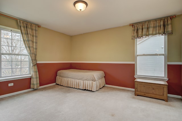 carpeted bedroom with baseboards and multiple windows