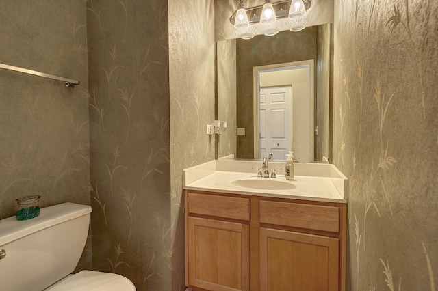 half bath featuring vanity and toilet
