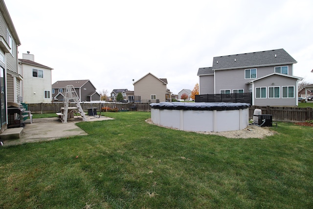 view of yard with a fenced backyard, a fenced in pool, a patio, a residential view, and central AC