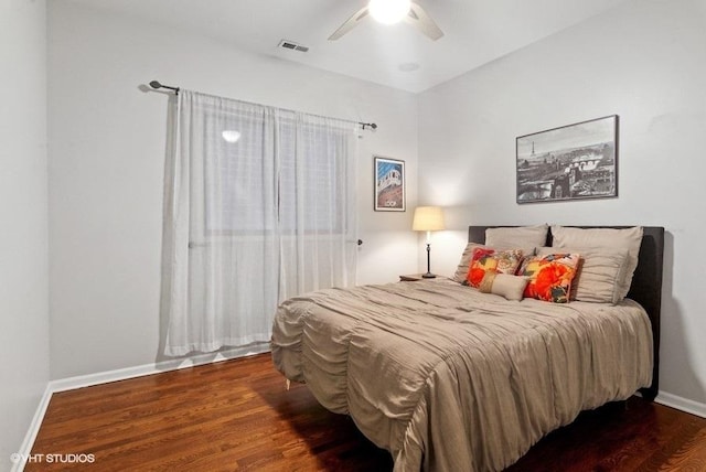 bedroom with visible vents, a ceiling fan, baseboards, and wood finished floors