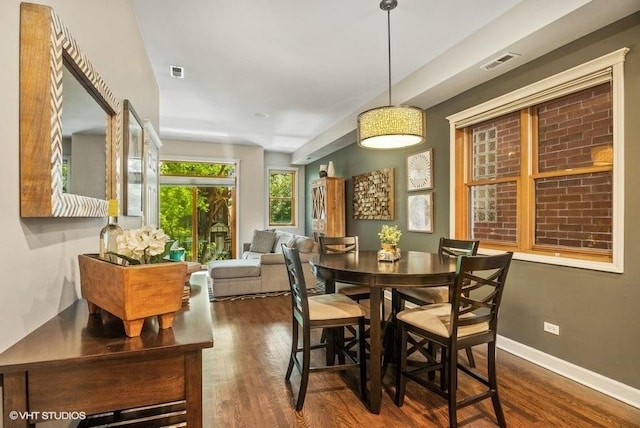 dining room featuring baseboards, visible vents, and wood finished floors