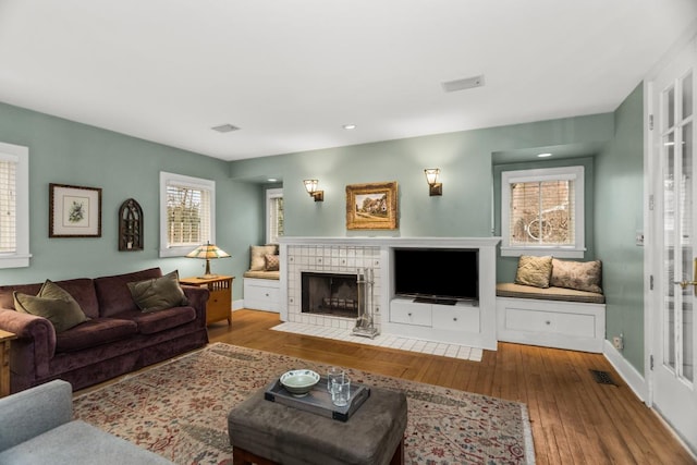 2717 Harrison St, Evanston, IL 60201 - living area with a tile fireplace, visible vents, hardwood / wood-style flooring, and baseboards