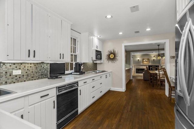 2717 Harrison St, Evanston, IL 60201 - kitchen with dark wood-style floors, recessed lighting, tasteful backsplash, black appliances, and light countertops