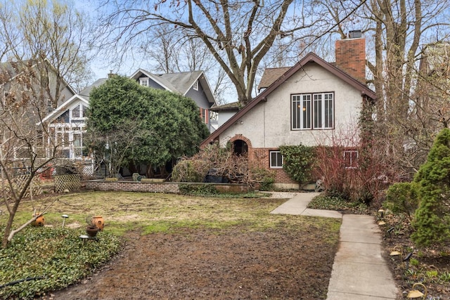 2717 Harrison St, Evanston, IL 60201 - view of front of house with stucco siding, a front lawn, a chimney, and brick siding