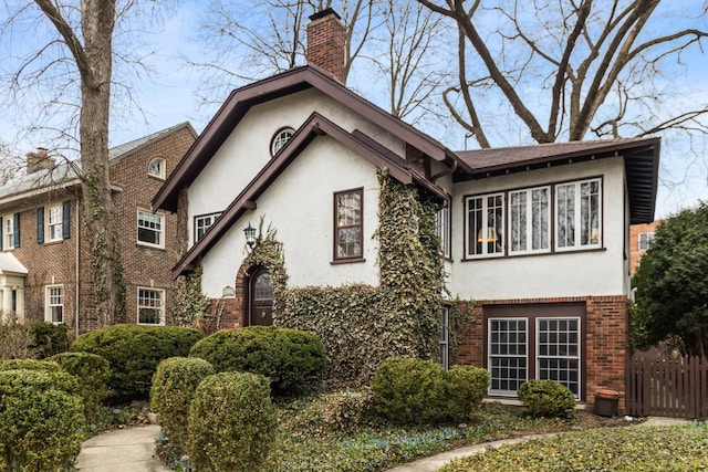 2717 Harrison St, Evanston, IL 60201 - view of front of property featuring stucco siding, fence, a chimney, and brick siding