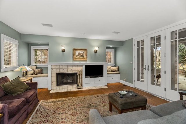 2717 Harrison St, Evanston, IL 60201 - living room with visible vents, french doors, a tile fireplace, recessed lighting, and wood finished floors
