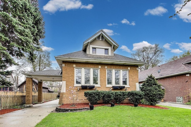 bungalow-style home featuring fence, driveway, a front lawn, and brick siding