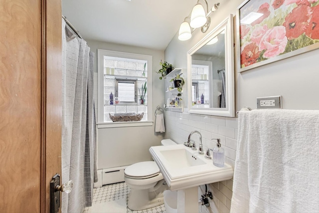 full bath with tasteful backsplash, baseboard heating, toilet, and tile walls