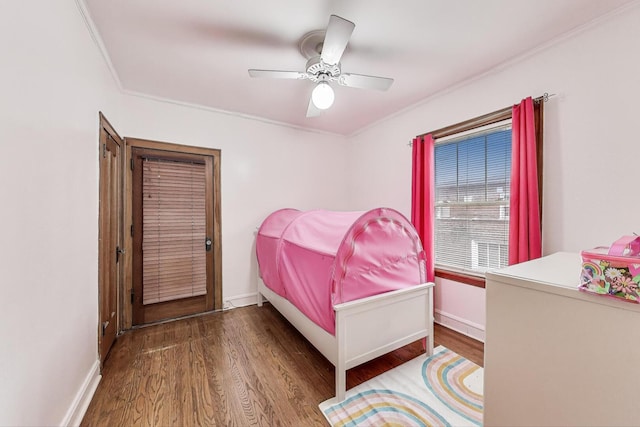 bedroom featuring baseboards, ornamental molding, a ceiling fan, and wood finished floors