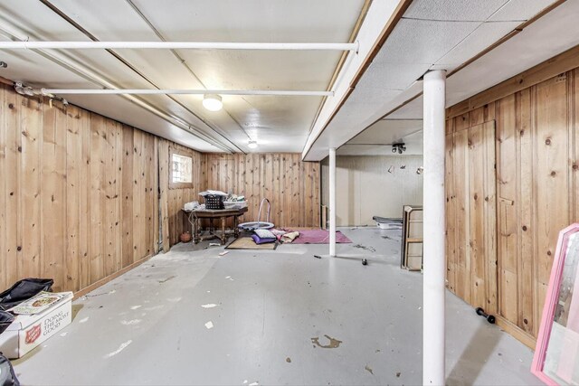 basement featuring wood walls
