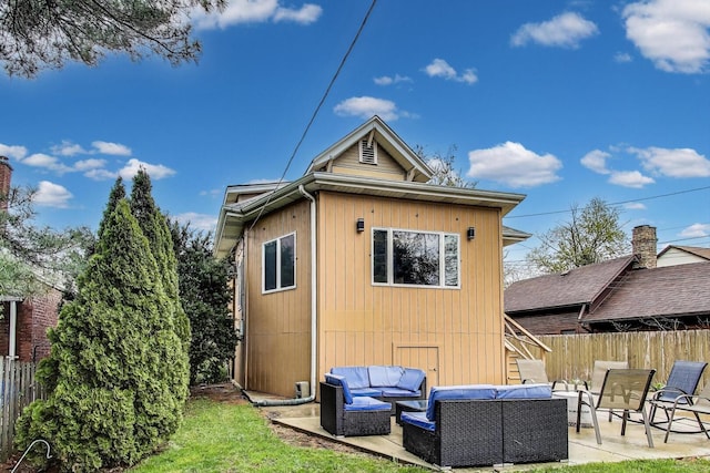back of house with an outdoor living space, fence, and a patio