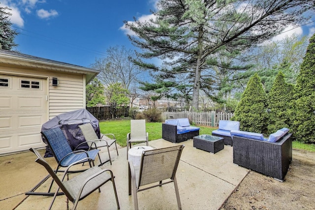 view of patio / terrace featuring outdoor lounge area, a fenced backyard, and a garage
