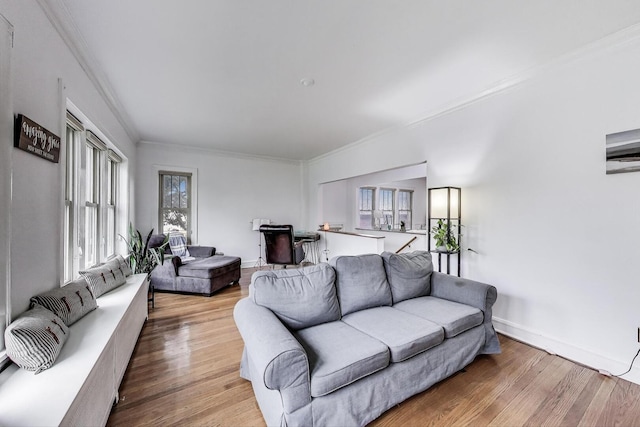 living room with crown molding, baseboards, and wood finished floors