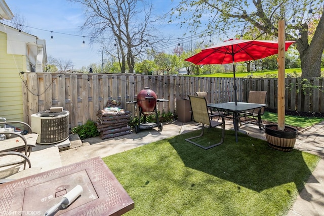 view of yard with a patio area, central air condition unit, outdoor dining area, and a fenced backyard