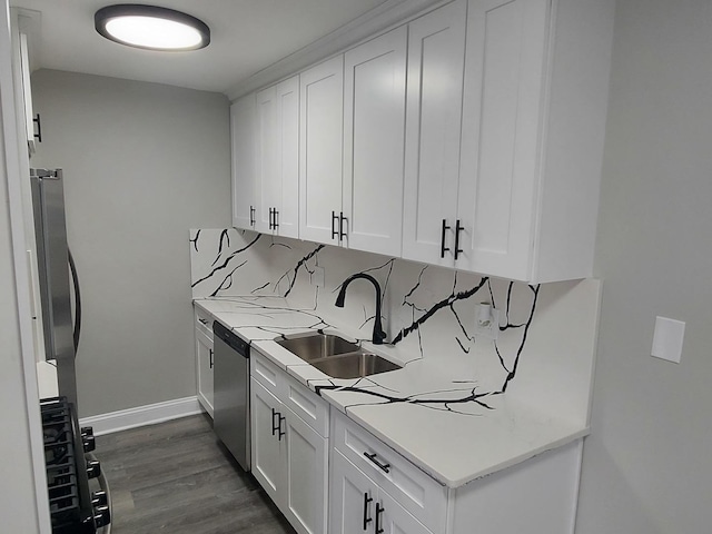kitchen featuring a sink, dark wood-type flooring, baseboards, light countertops, and stainless steel dishwasher