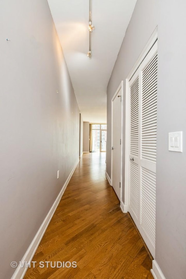 corridor with wood finished floors and baseboards
