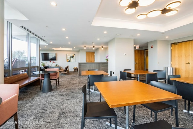 carpeted dining room featuring recessed lighting, a tray ceiling, and floor to ceiling windows