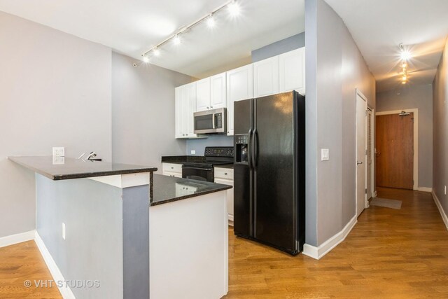 kitchen featuring black appliances, track lighting, white cabinets, a peninsula, and light wood-style floors