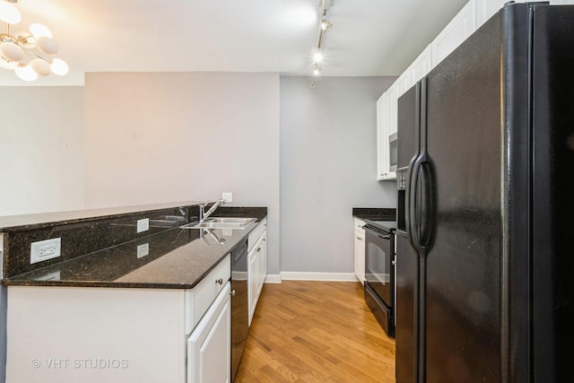 kitchen featuring black appliances, a sink, light wood-style flooring, white cabinetry, and a peninsula