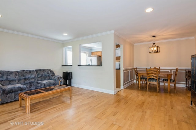 living room featuring an inviting chandelier, recessed lighting, light wood-style flooring, and crown molding