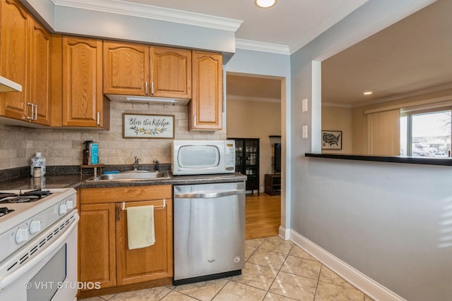 kitchen with a sink, brown cabinets, backsplash, and white appliances