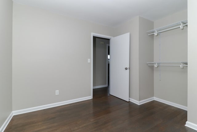 unfurnished bedroom featuring a closet, wood finished floors, and baseboards