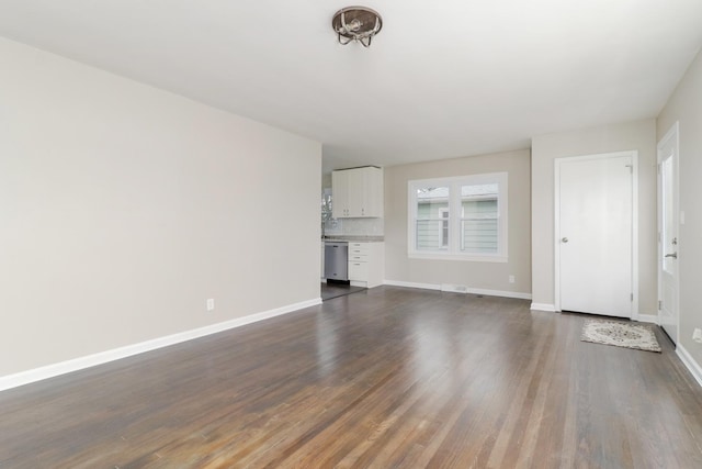 unfurnished living room with dark wood finished floors and baseboards
