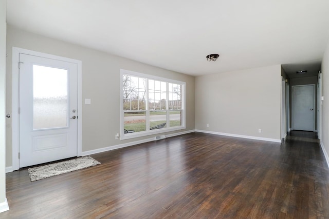 foyer featuring dark wood finished floors and baseboards