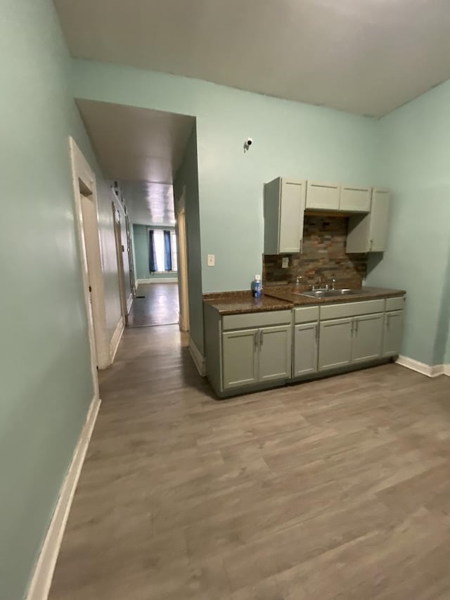 6618 S Marquette Rd, Chicago, IL 60637 - kitchen featuring baseboards, decorative backsplash, light wood-type flooring, and dark countertops