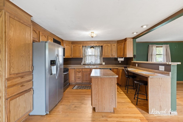 510 W 3rd St, Braidwood, IL 60408 - kitchen featuring a kitchen island, light wood-type flooring, stainless steel appliances, and a peninsula